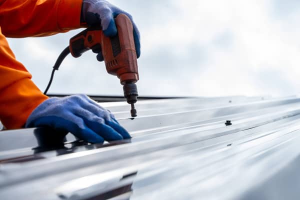 Installation of sheet metal roofing by contractors.