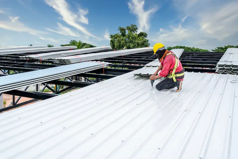 A worker installing a new roof with safety tools